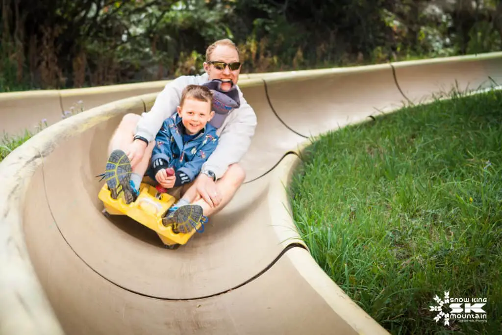 Father and son riding the Snow King Mountain Alpine Slide in summer.